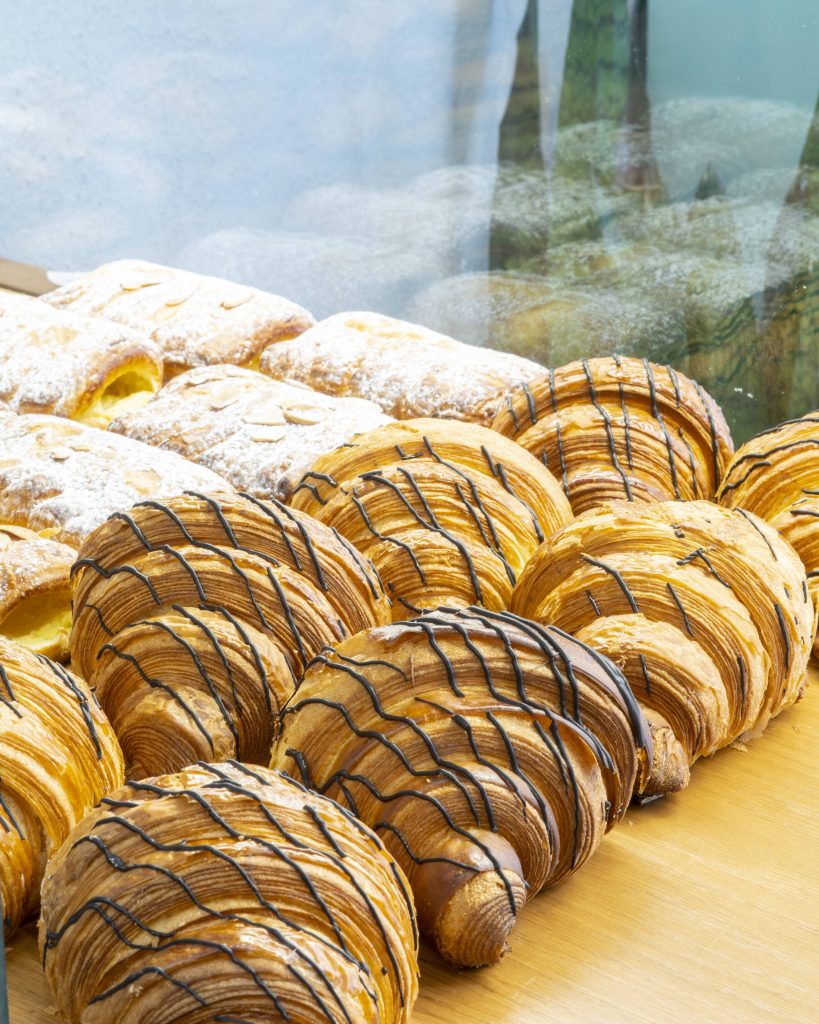 کروسان‌ها و شیرینی‌های تازه در اغذیه‌فروشی شاهی در محله‌ی سنایی